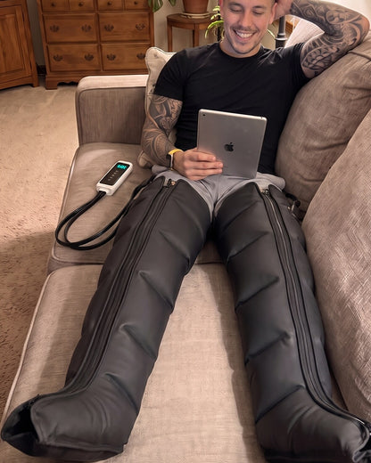LegRenew Pro boots on the couch while reading